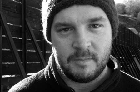 Black and white headshot of writer Jeffrey McDaniel in a beanie.