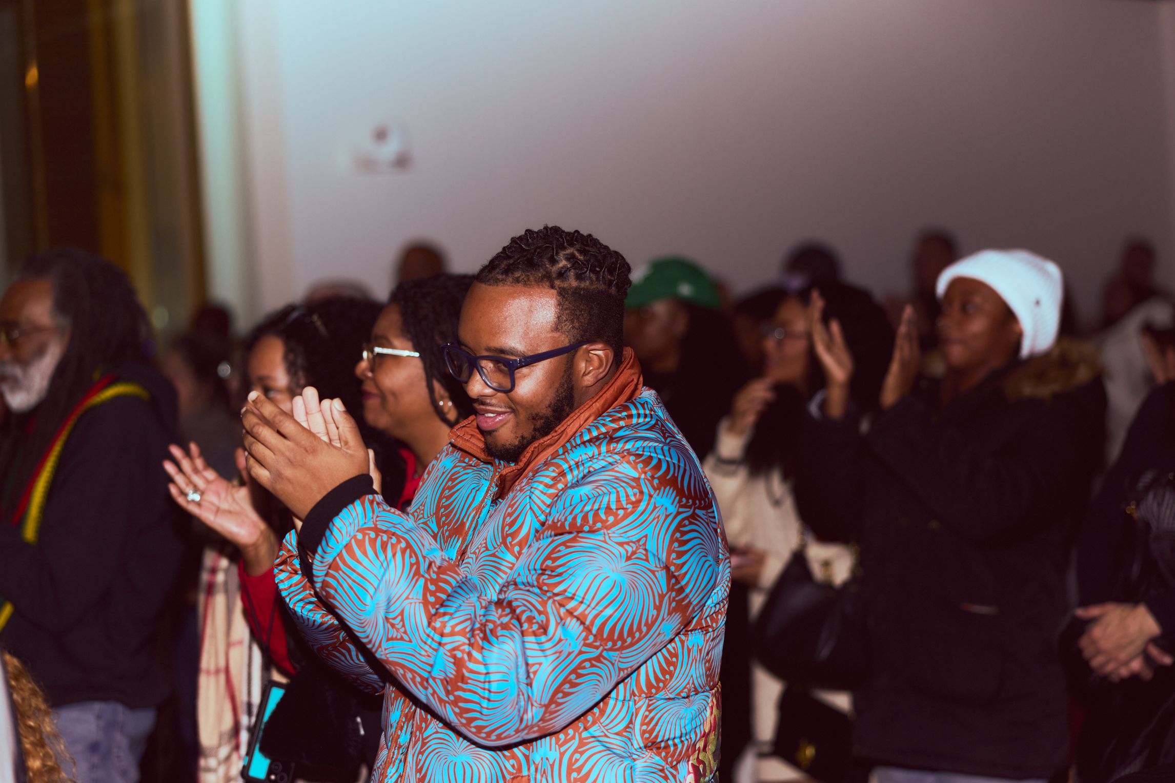 Crowd of adults in a venue standing and clapping