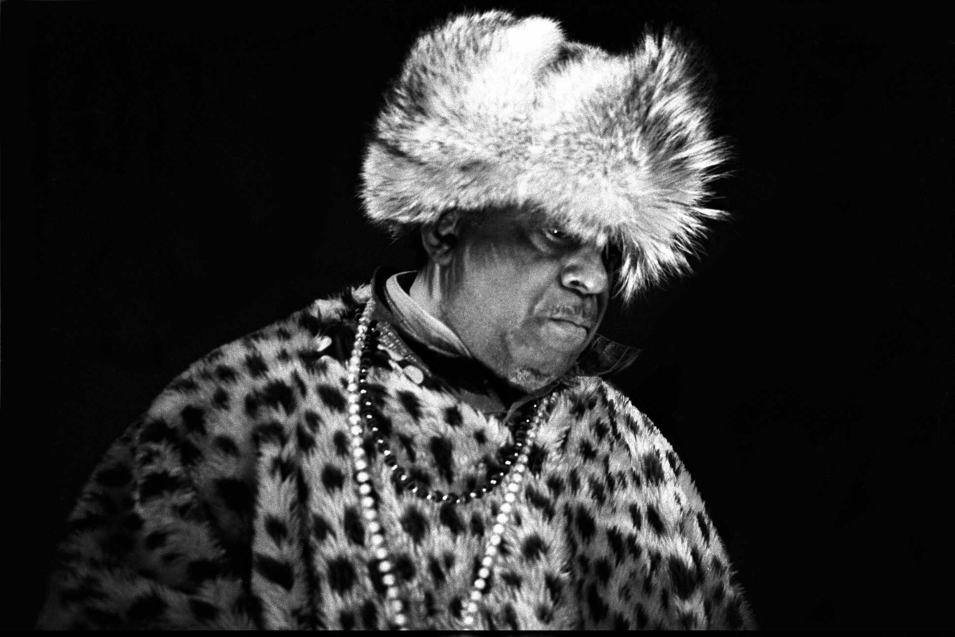 Cropped black and white image of the musician and poet Sun Ra in performance.