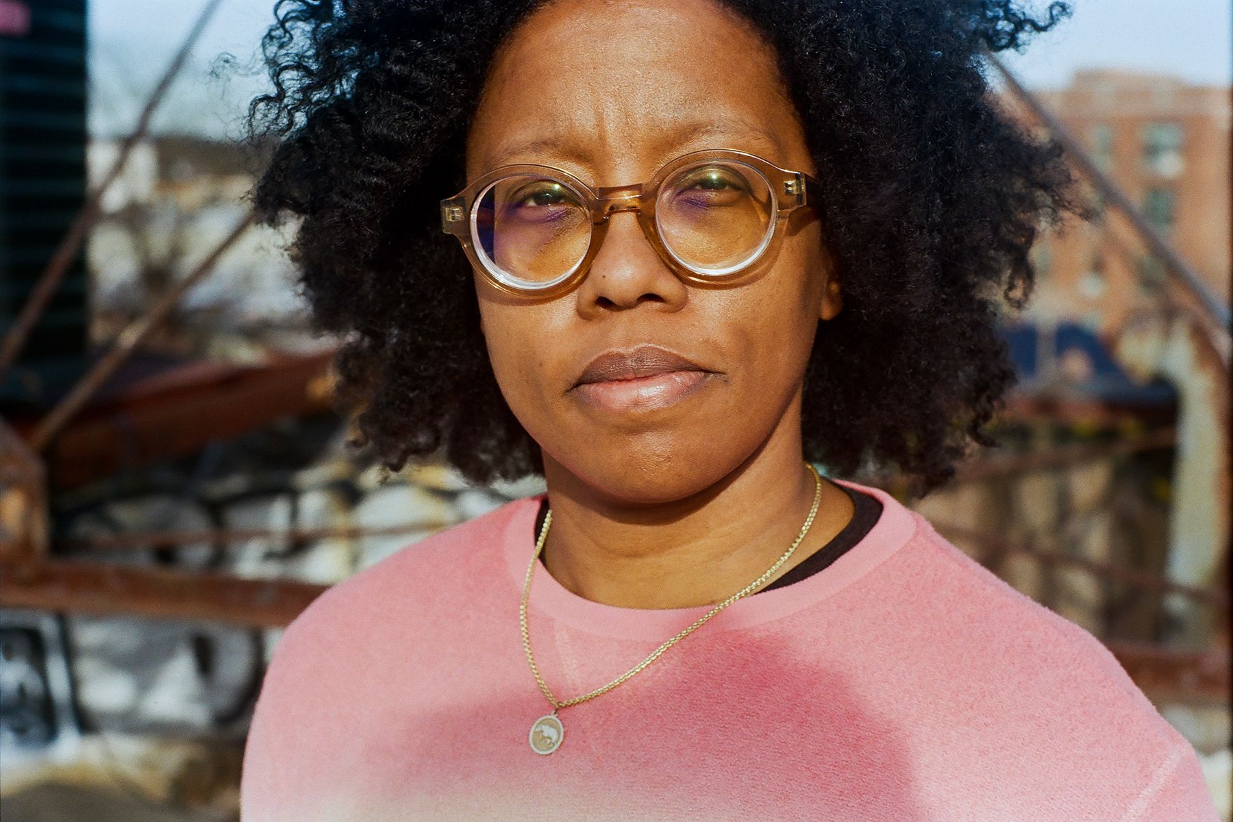 Donika Kelly, a black woman, stands outside facing the sun.