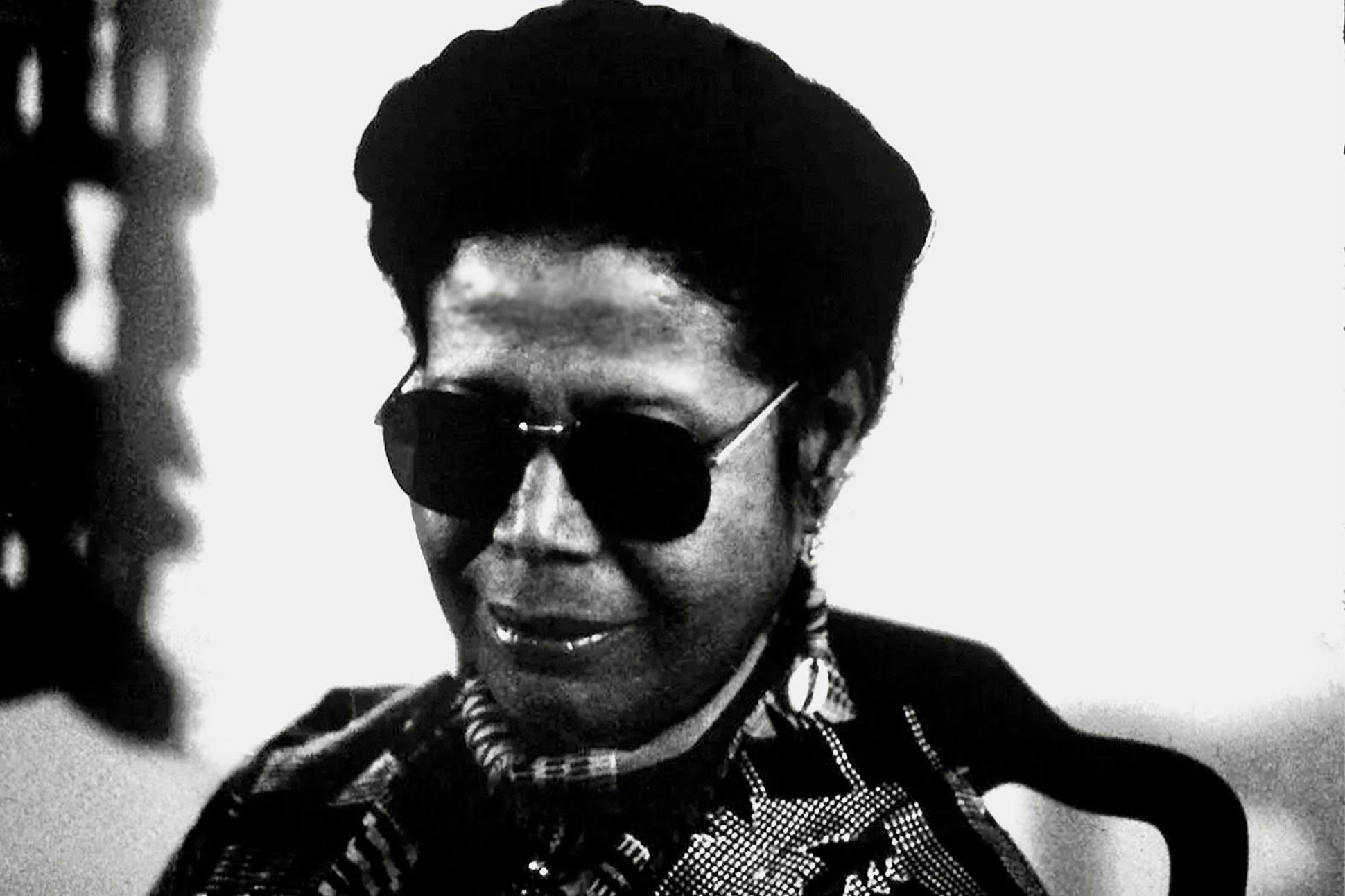 A black-and-white photograph of Jayne Cortez wearing sunglasses.