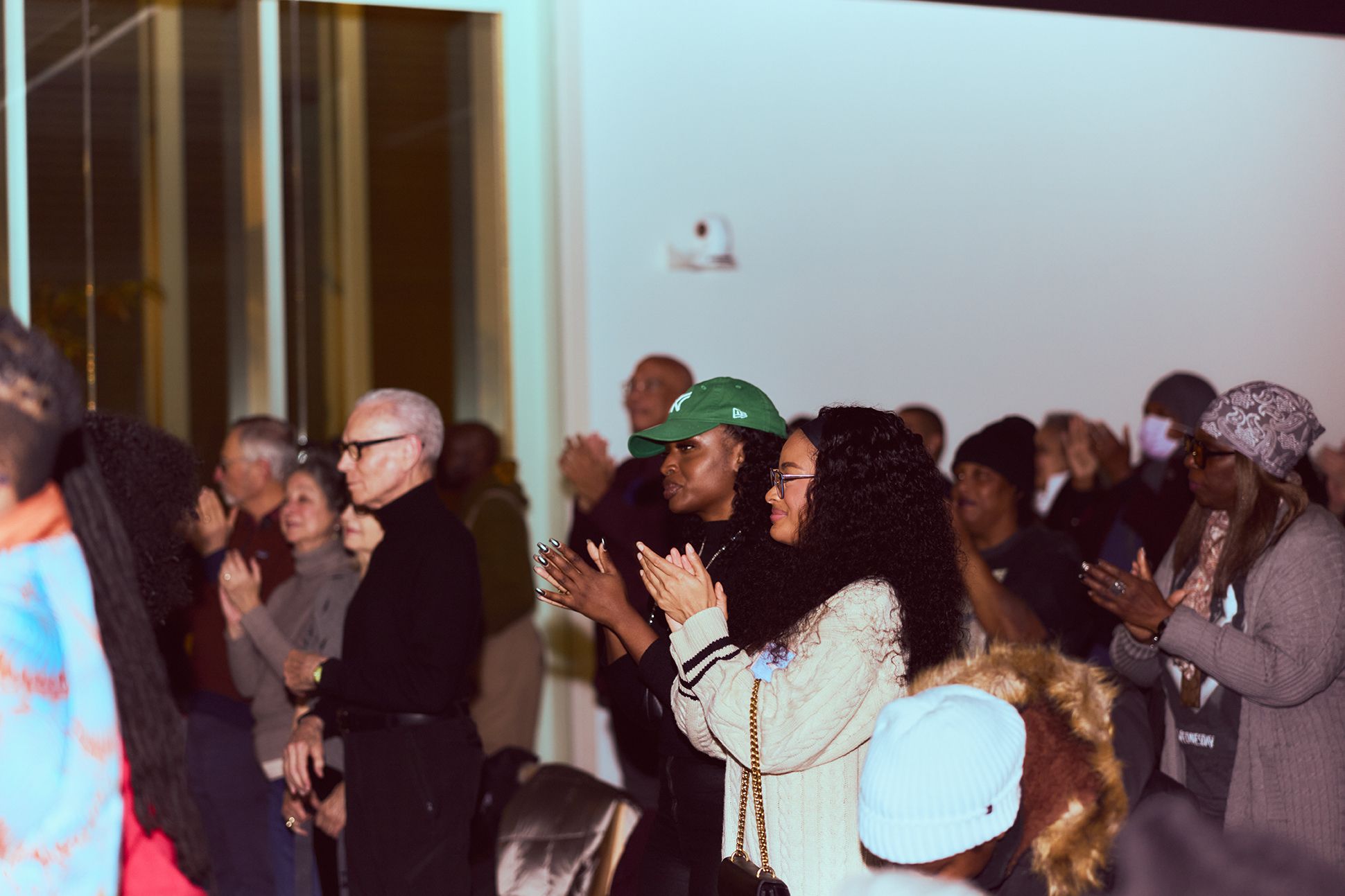 Crowd of adults in a venue standing and clapping