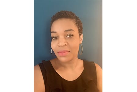 A black woman in loop rings and black tank top