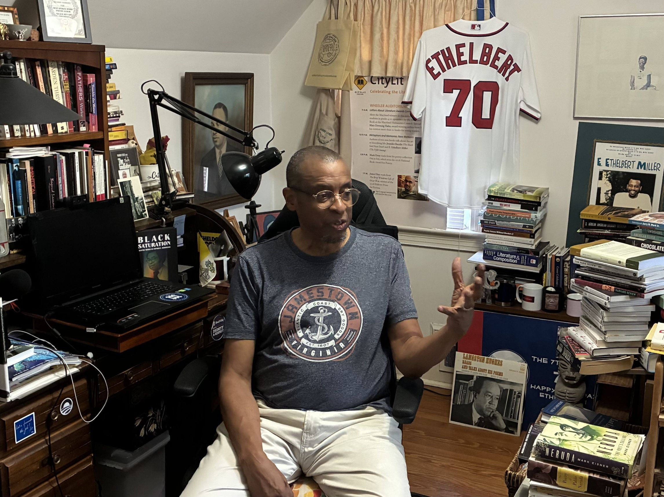 Candid photo of E Ethelbert Miller speaking in his home office