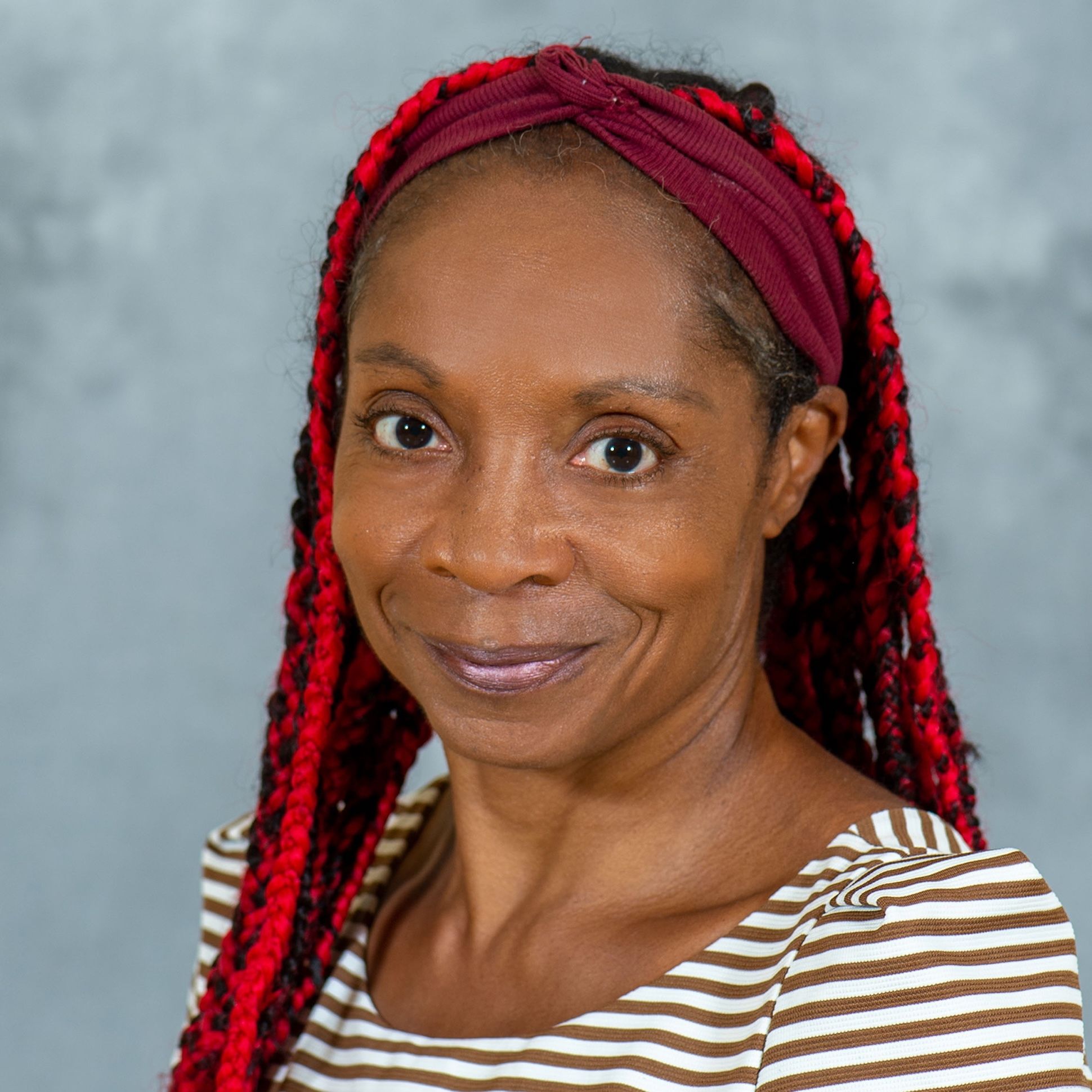 Allison Joseph, a black woman with red braided hair, smiles for a photo