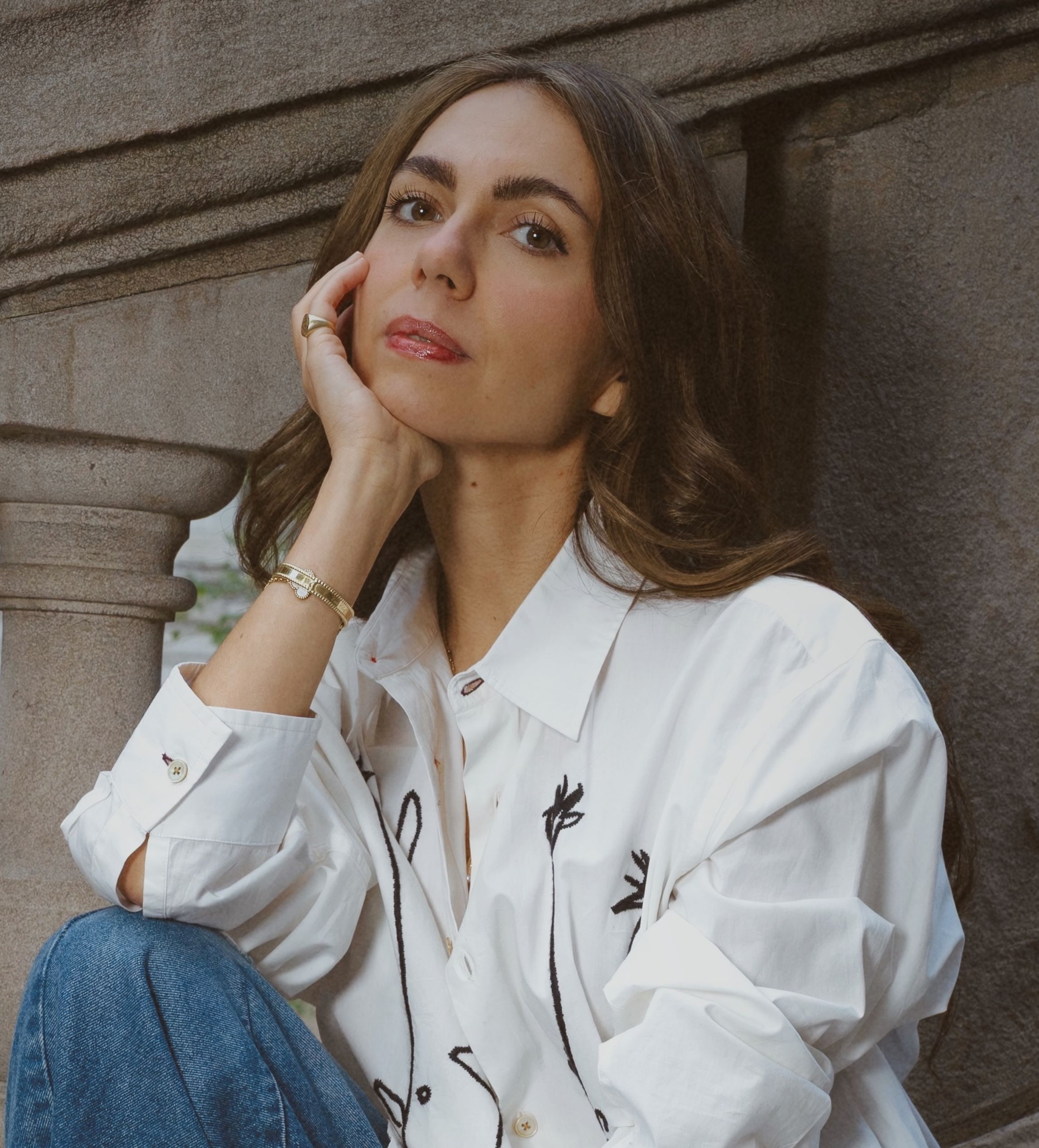 Maya C. Popa, a white woman with dark brown hair, sits on steps