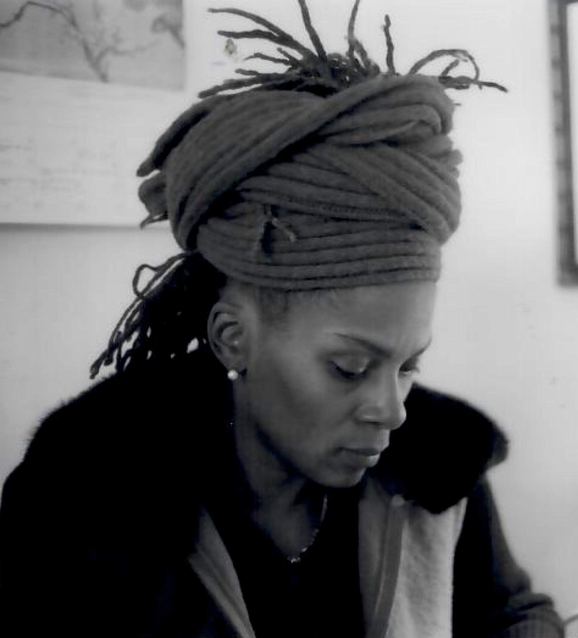Black and white photo of julie ezelle patton. patton is shown in profile, looking down, with locs half up in a headwrap.