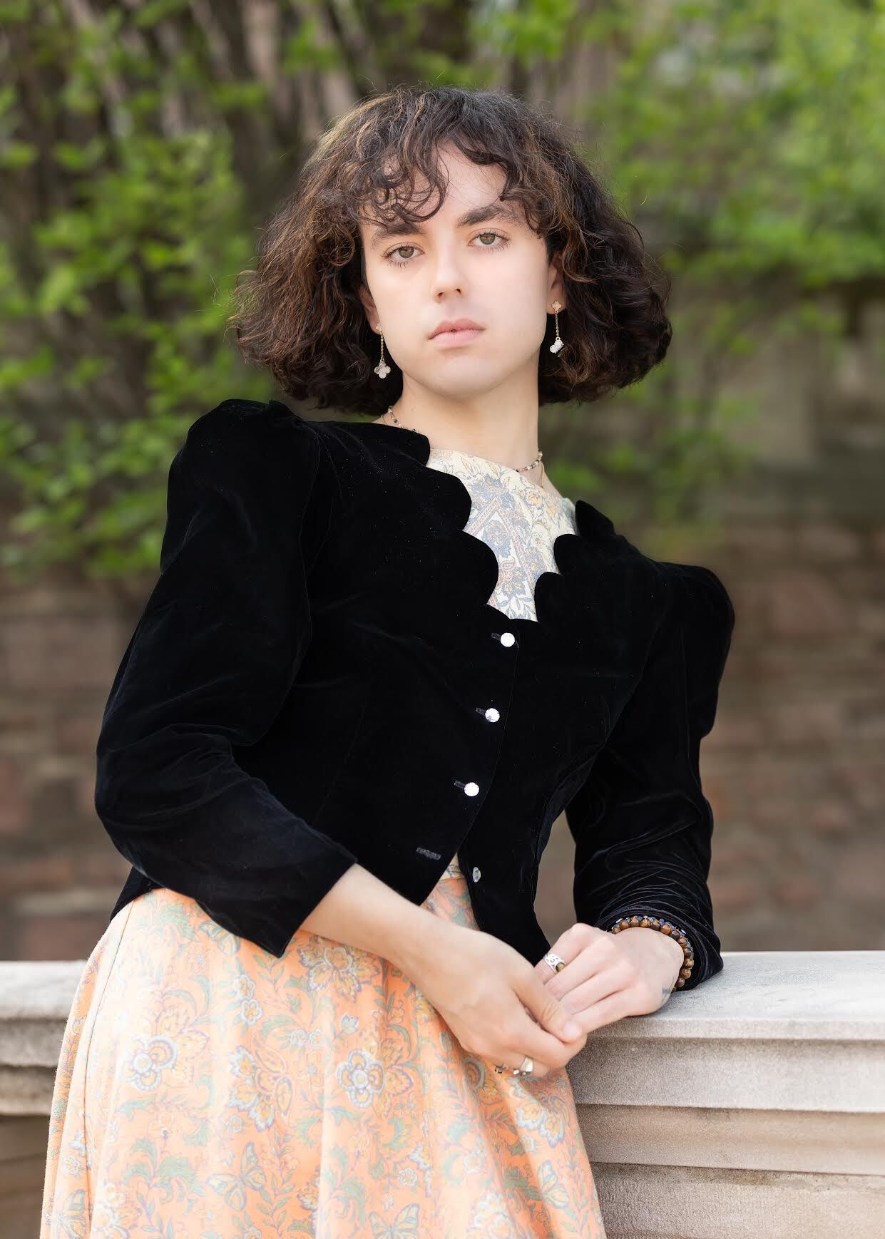 Temperance Aghamohammadi, wearing a vintage dress, leans against a marble ledge